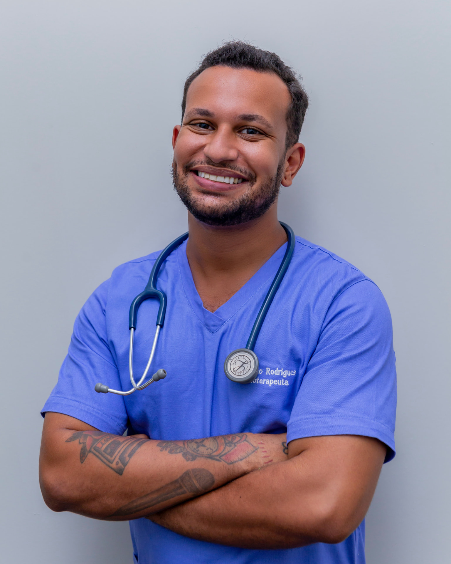 Nurse in blue scrubs with a stethoscope, arms crossed